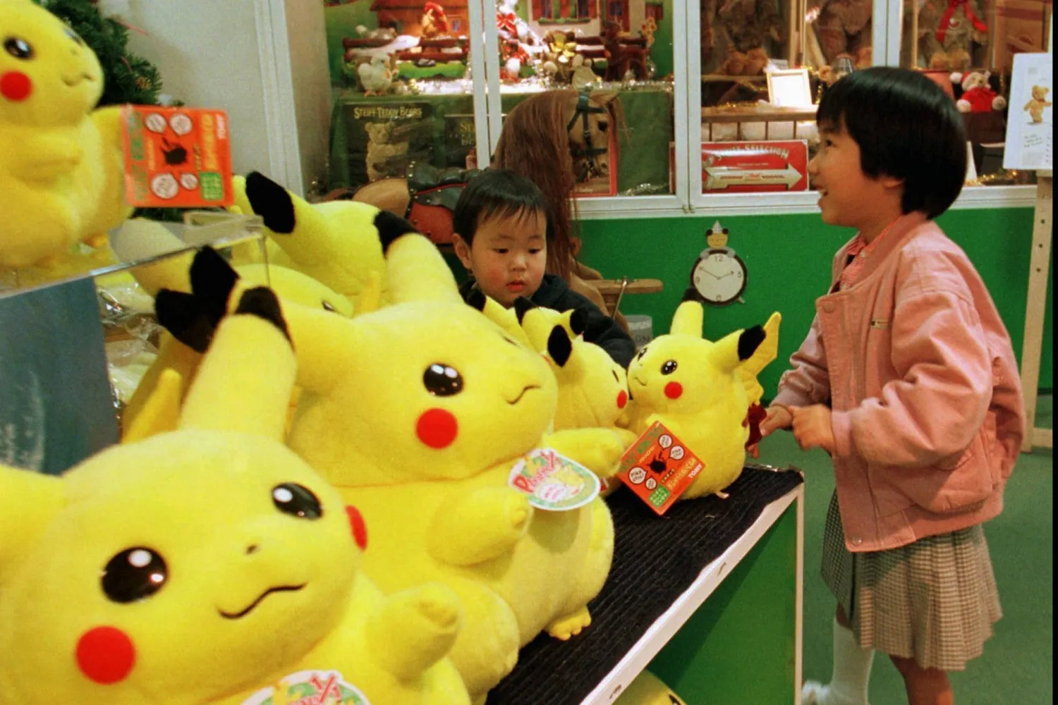 A Japanese girl and her brother play with dolls of a popular cartoon character, "Pokémon," at a toy shop in Tokyo's Ginza shopping district, Dec. 18, 1997. (AP)