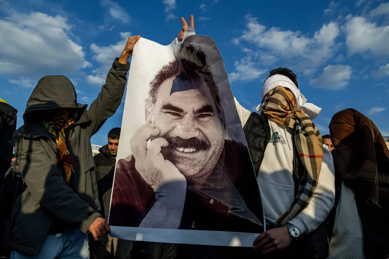 FILE - Youngsters hold a photograph of Abdullah Ocalan, the jailed PKK leader in Diyarbakir, Türkiye, Feb. 27, 2025. (AP Photo/Metin Yoksu, File)