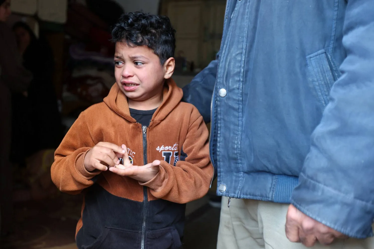 طفل فلسطيني خلال تشييع والده الشرطي الذي قُتل بغارة إسرائيلية في خان يونس الجمعة (رويترز)