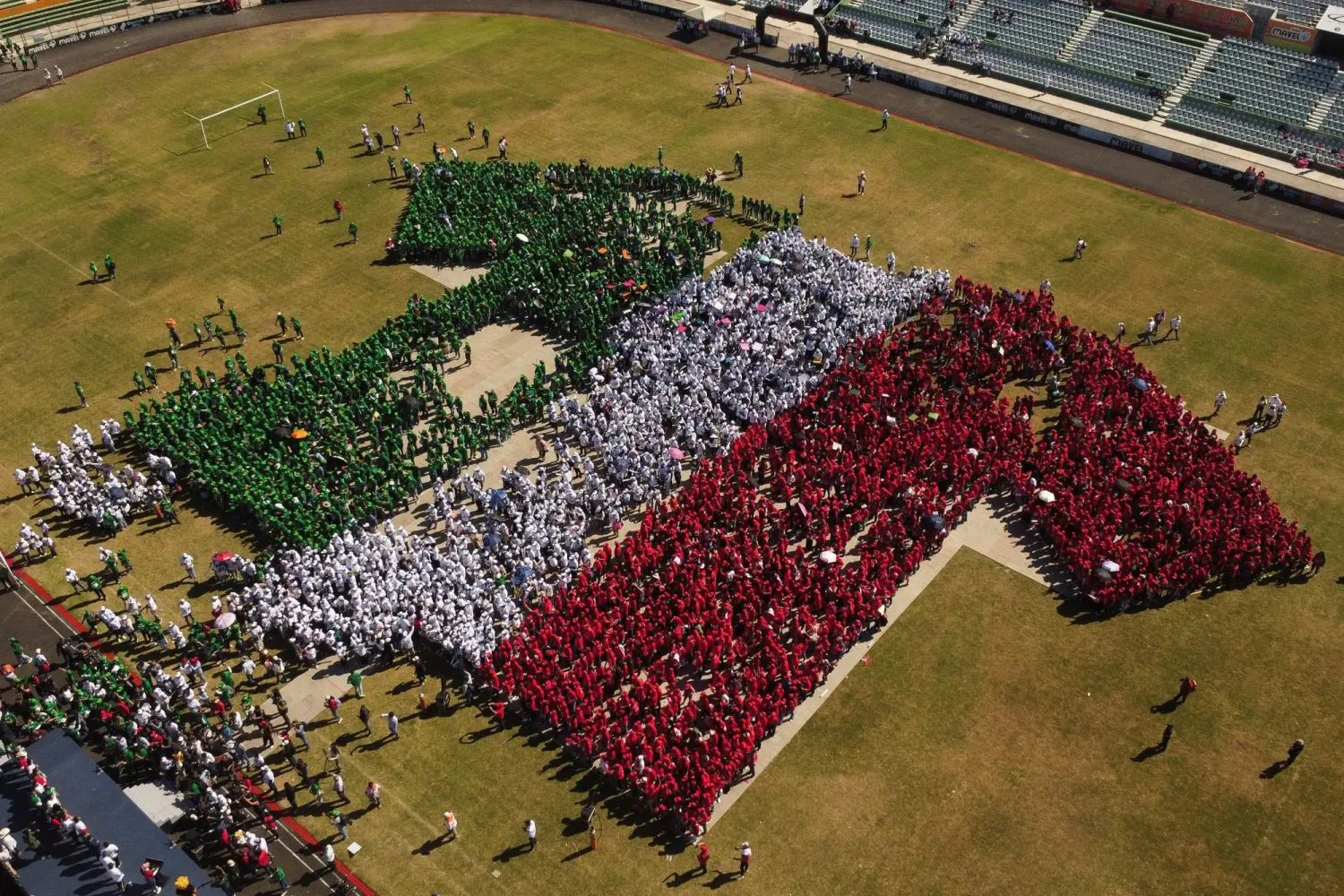 Volunteers line up to form the Mexican national team jersey at the Victor Manuel Stadium in Tuxtla Gutiérrez (Reuters)