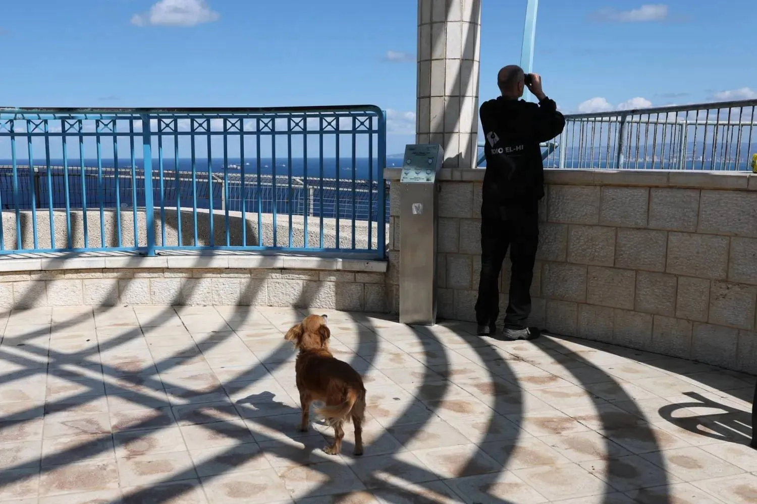 Man uses binoculars to watch the Mediterranean ahead of the expected arrival of the aircraft carrier Gerald Ford at Haifa port (EPA)