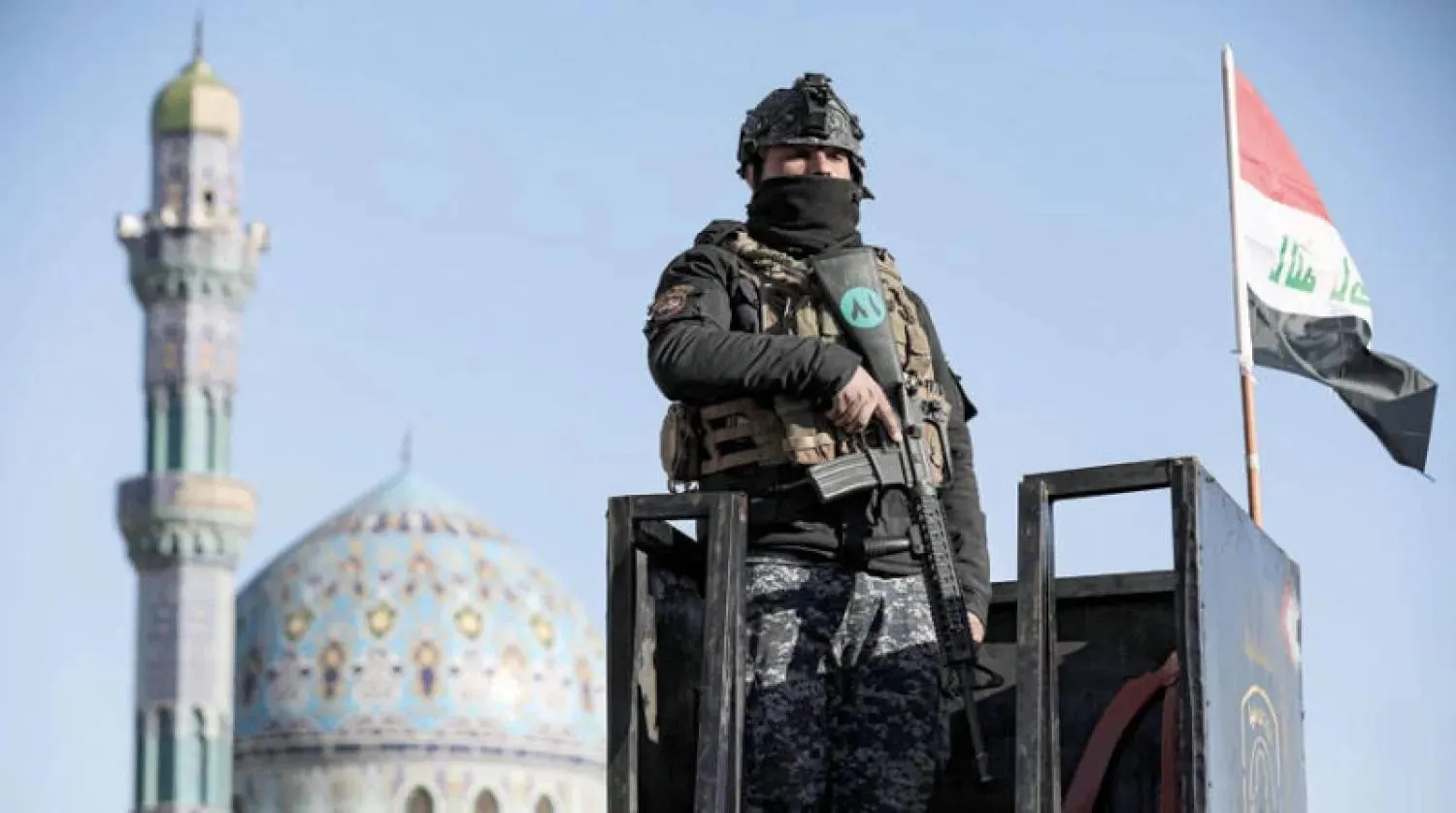 رجل أمن عراقي يقف على برج مراقبة في بغداد (د.ب.أ)