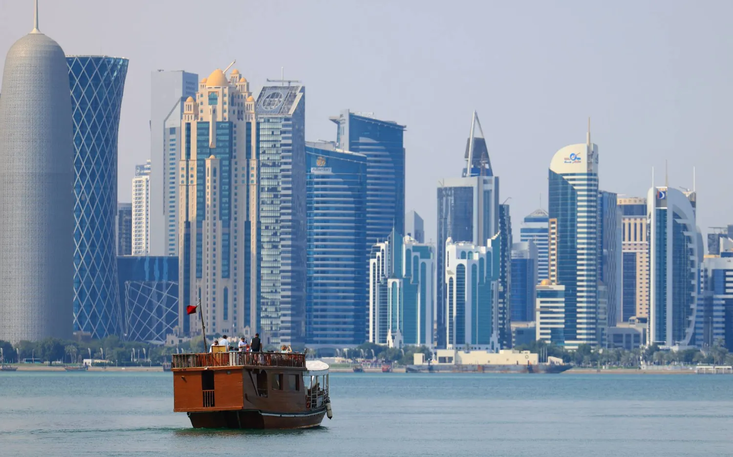 A traditional dhow boat with tourists travels on the waters of the Persian Gulf in front of the West Bay skyline in Doha, Qatar, 27 February 2026. (EPA)