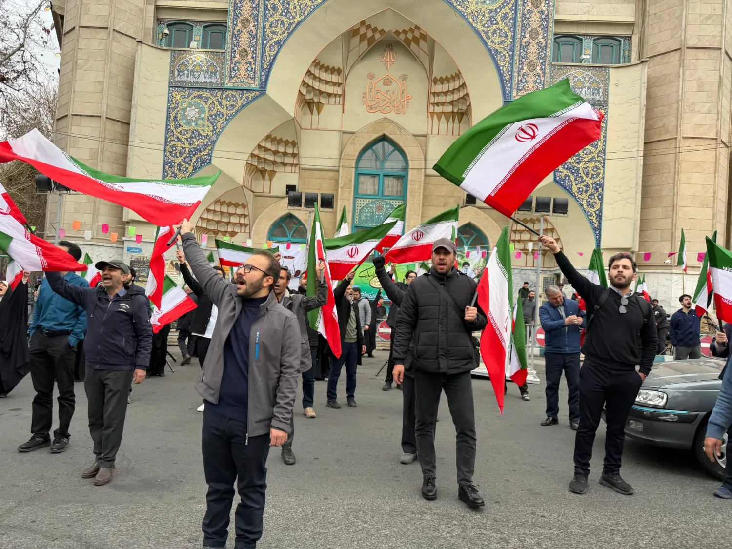 A group of men wave Iranian flags as they attend a demonstration in support of the government and against US and Israeli strikes in Tehran, Iran, Saturday, Feb. 28, 2026. (AP Photo/Vahid Salemi)