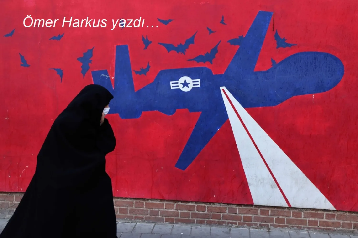 Tahran'daki eski ABD büyükelçiliğindeki bir duvar resminin önünde İranlı kadın, 1 Şubat (AFP)