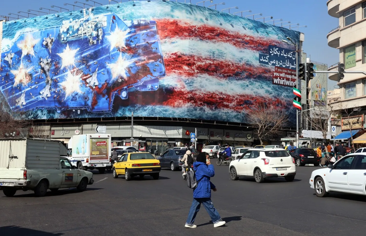 Iranians walk past an anti-US billboard at Enqelab Square in Tehran, Iran, 16 February 2026. (EPA) 
