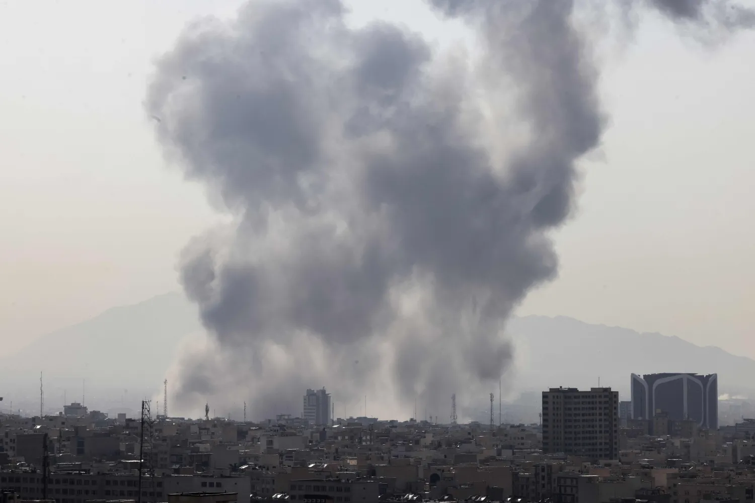A plume of smoke rises following a reported explosion in Tehran on February 28, 2026. (Photo by ATTA KENARE / AFP)