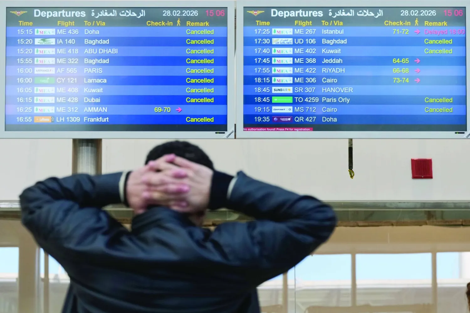 A traveler checks departure times as many flights are cancelled at Beirut Rafik Hariri International Airport in Beirut, Lebanon, Saturday, Feb. 28, 2026, as many airlines canceled flights due to the conflict involving the United States, Israel and Iran. (AP Photo/Hassan Ammar)