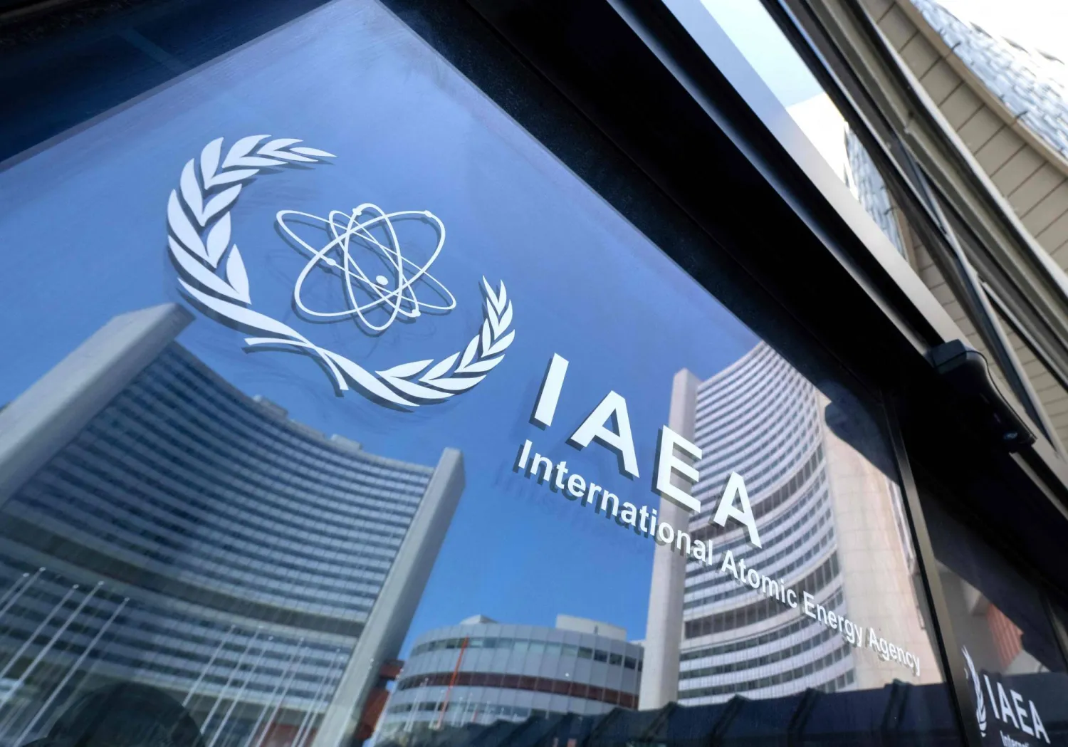 Buildings of the International Atomic Energy Agency (IAEA) headquarters reflect in doors with the agency's logo during the IAEA's Board of Governors meeting in Vienna, Austria on June 13, 2025. (AFP)