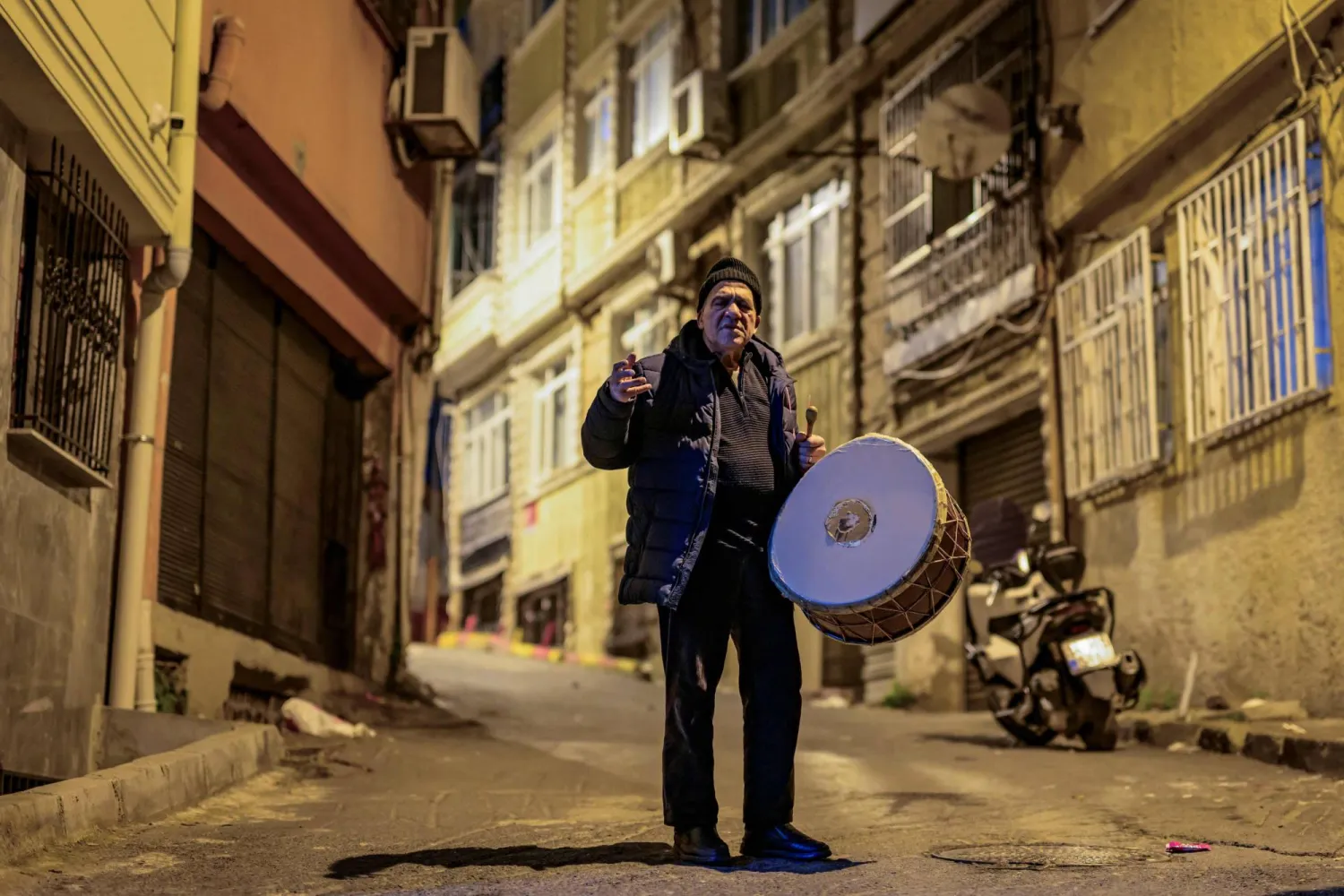 Turkish drummer Hakan Ozbingol plays drum and sings traditional songs in the streets of Istanbul, to wake Muslims up for the suhour, the Ramadan meal eaten at night, on February 24, 2026. (AFP) 