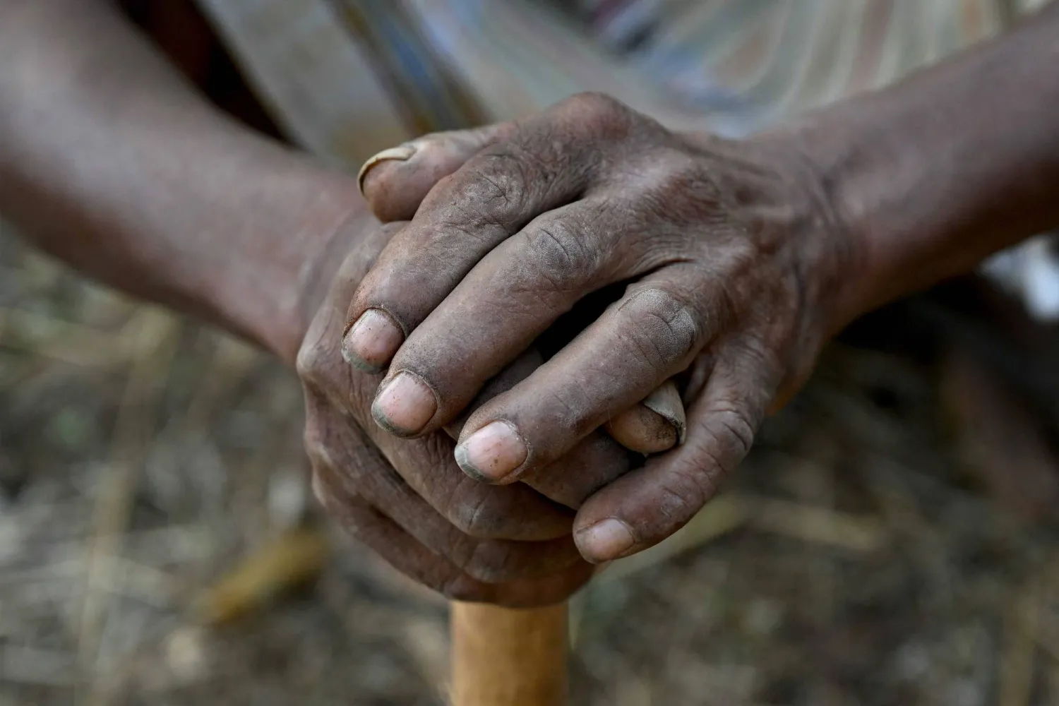 This photograph taken on February 14, 2026 shows hands of a wage-labourer under Mahatma Gandhi National Rural Employment Guarantee Act (MGNREGA) toiling a dirt road at a road-construction site at Balapur Dolkarpada village in Maharashtra's Palghar district. (AFP) 