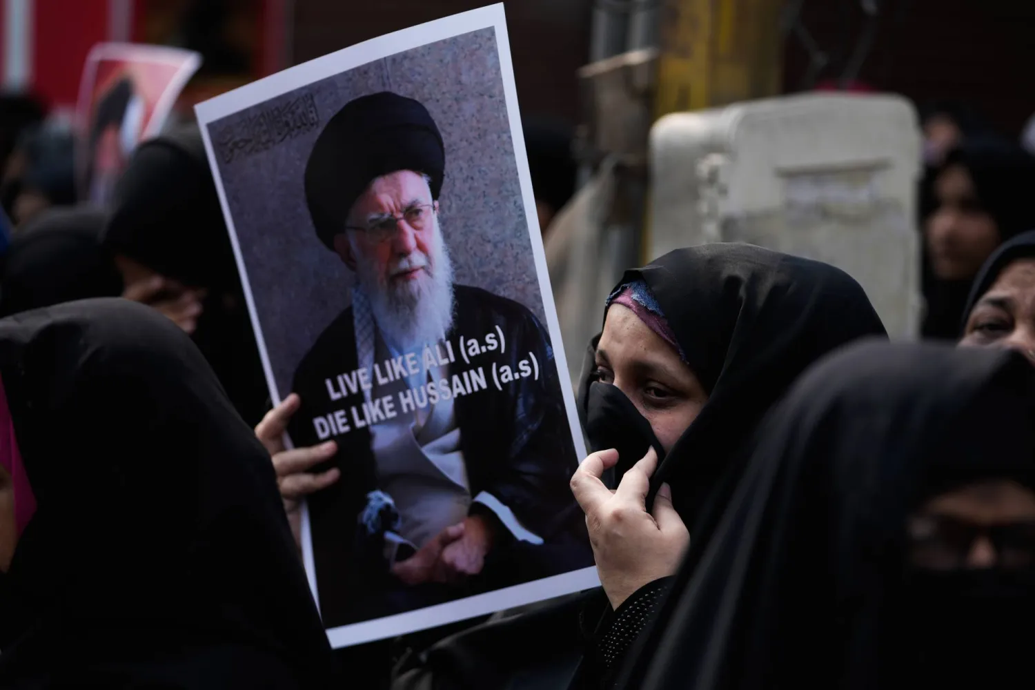 سيدة ترفع صورة المرشد الإيراني علي خامنئي خلال مظاهرة في الهند عقب مقتله في قصف أميركي إسرائيلي على إيران (أ.ب)