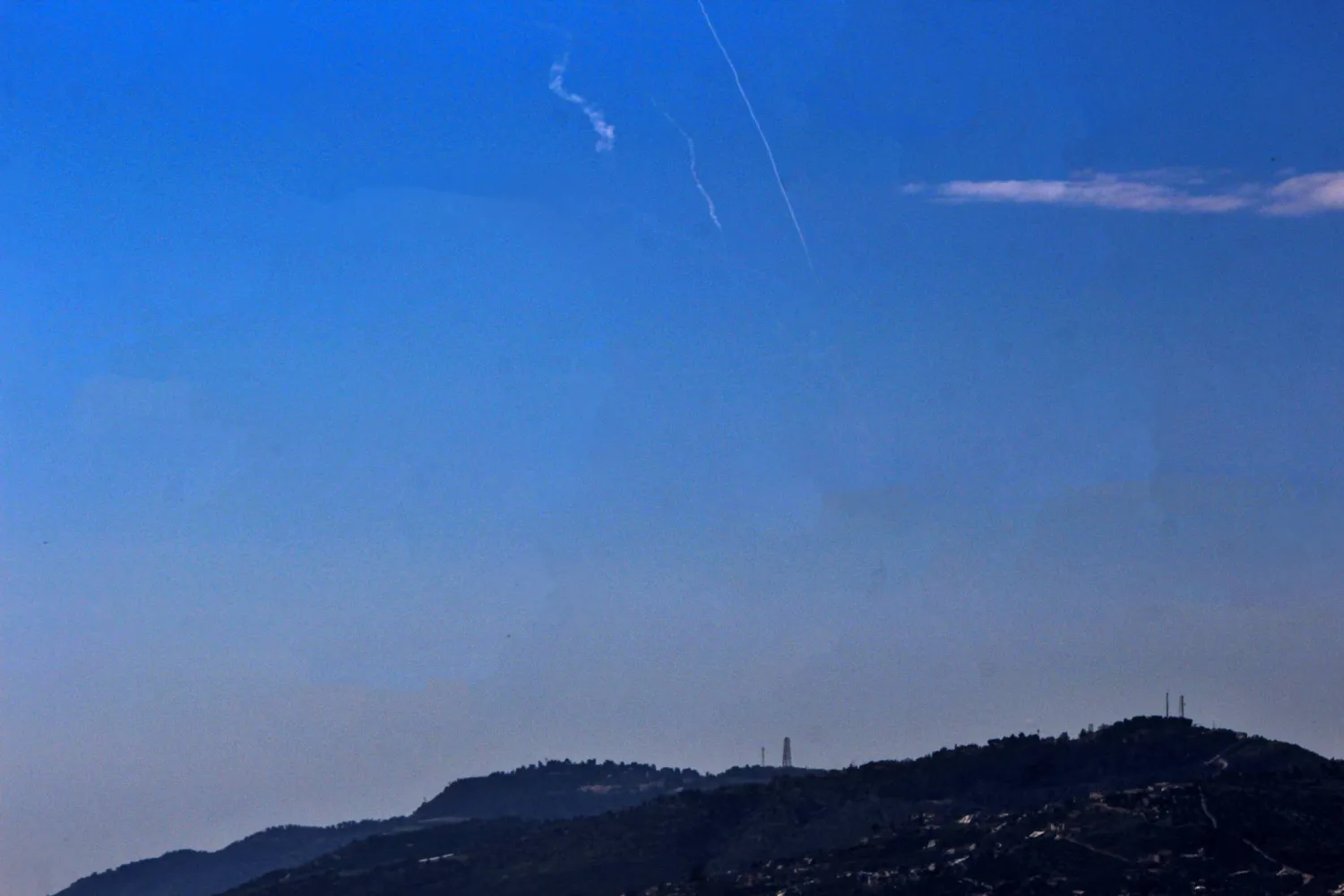 01 March 2026, Lebanon, Qliyaa: Smoke trails left by interceptor missiles launched from Israeli air defense systems to counter Iranian missiles is seen over the Israeli settlement of Metula as seen from the Lebanese southern border village Qliyaa.(dpa)