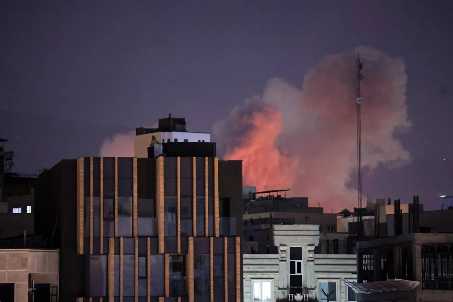 تصاعد الدخان خلف المباني بعد انفجار وقع في اليوم الثاني على التوالي من الضربات التي شنتها الولايات المتحدة وإسرائيل في طهران (إ.ب.أ)