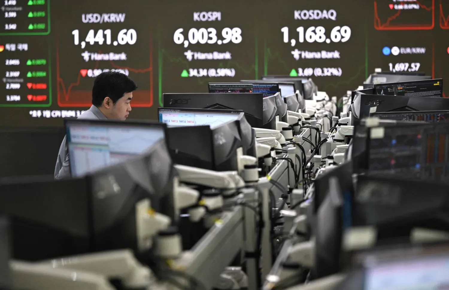 Seul’deki Hana Bank’ta bir yatırımcı, KOSPI endeksini gösteren ekranı izliyor. (AFP)