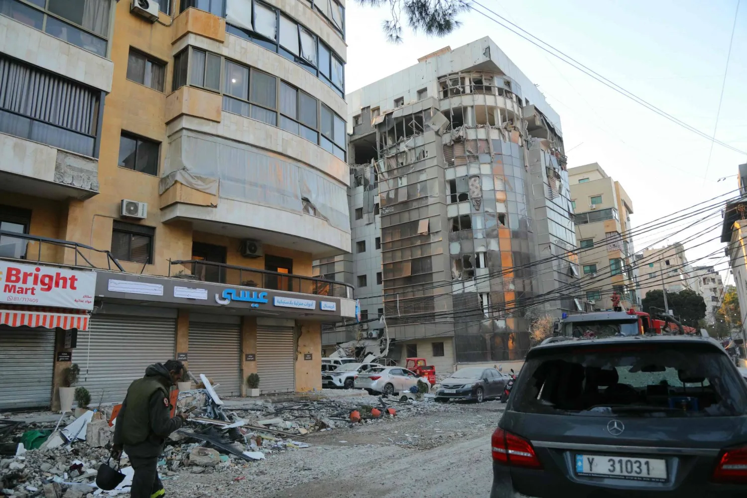 TOPSHOT - A man walks past a building damaged after an Israeli airstrike in Beirut's southern suburb neighborhood of Haret Hreik on March 2, 2026. (Photo by Ibrahim AMRO / AFP)