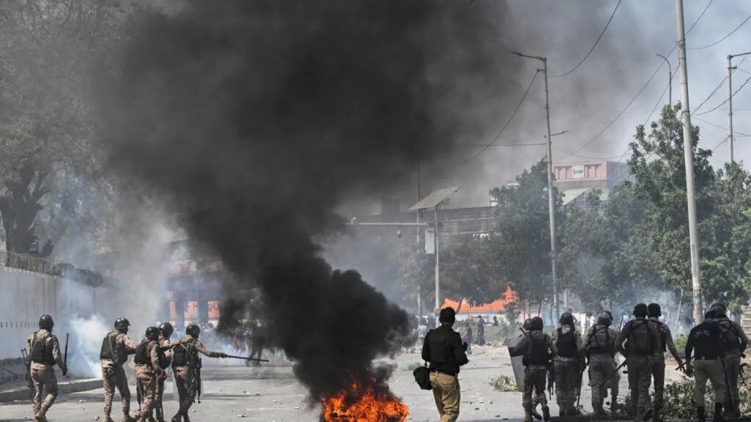Security personnel fire tear gas as Shiite Muslims shout slogans during a protest outside the US consulate in Karachi after the death of Iran's supreme leader Ali Khamenei amid US-Israel strikes. Asif HASSAN / AFP
