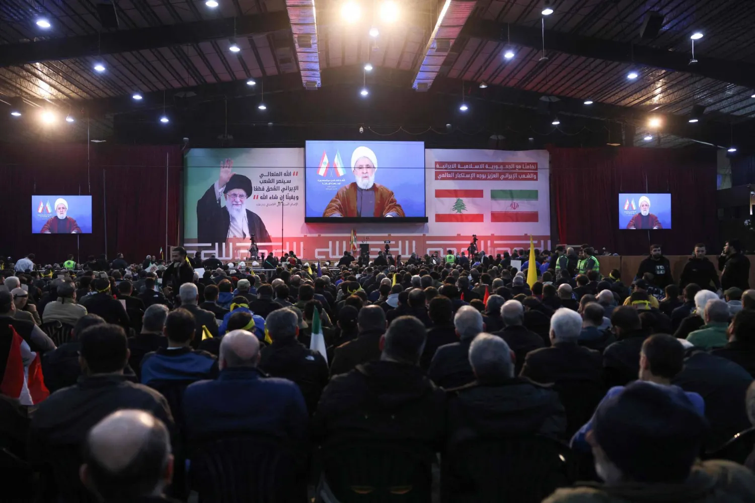 Supporters watch a televised speech by Hezbollah chief Naim Qassem during a rally to show their solidarity with Iran, in the southern suburb of Beirut on January 26, 2026. (Photo by Anwar AMRO / AFP)