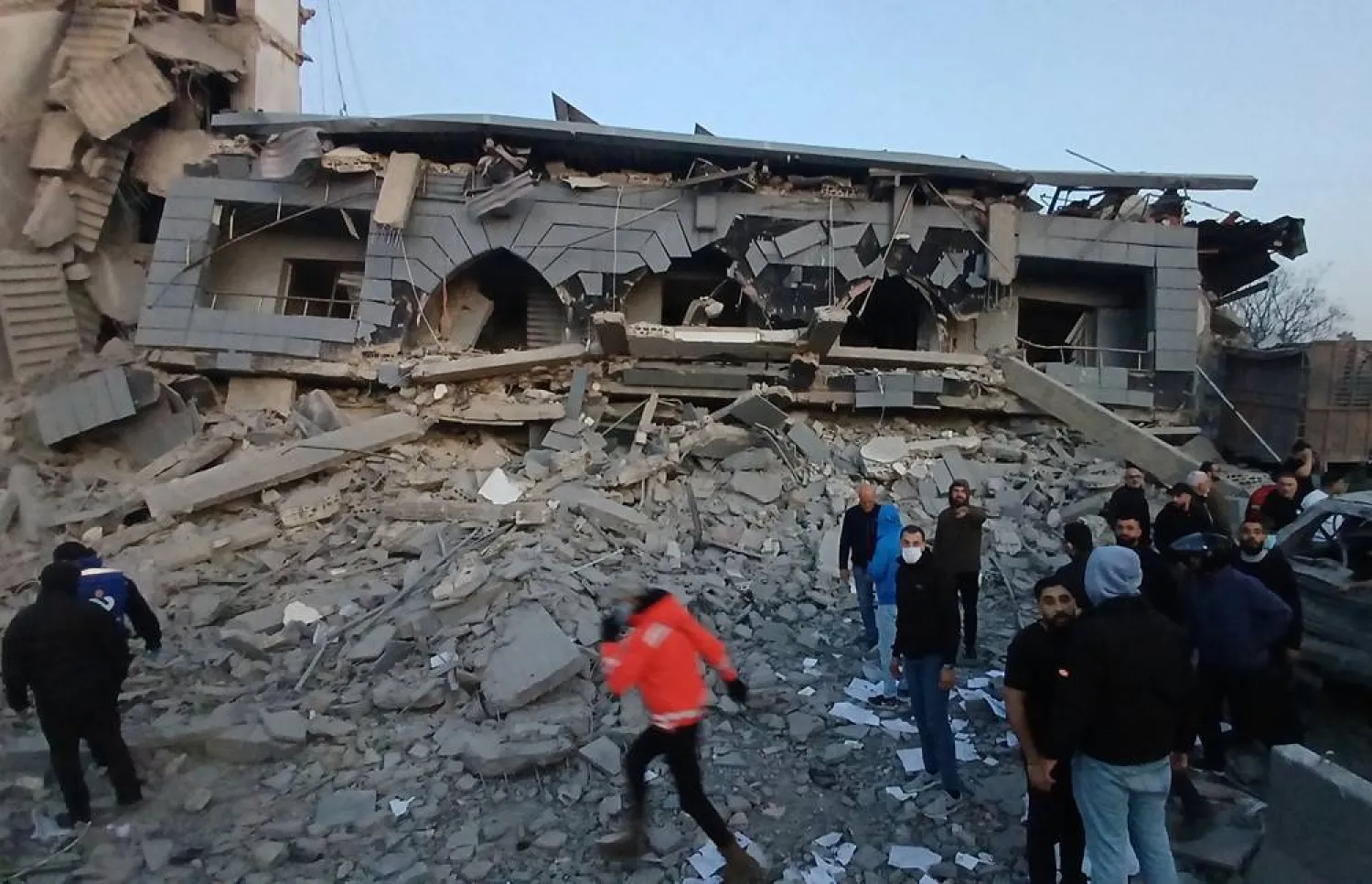 Rescue workers gather in front of the destroyed center of the Jamaa Islamiya group which hit by an Israeli strike, in the southern port city of Sidon, Lebanon, Tuesday, March, 3, 2026. (AP) 