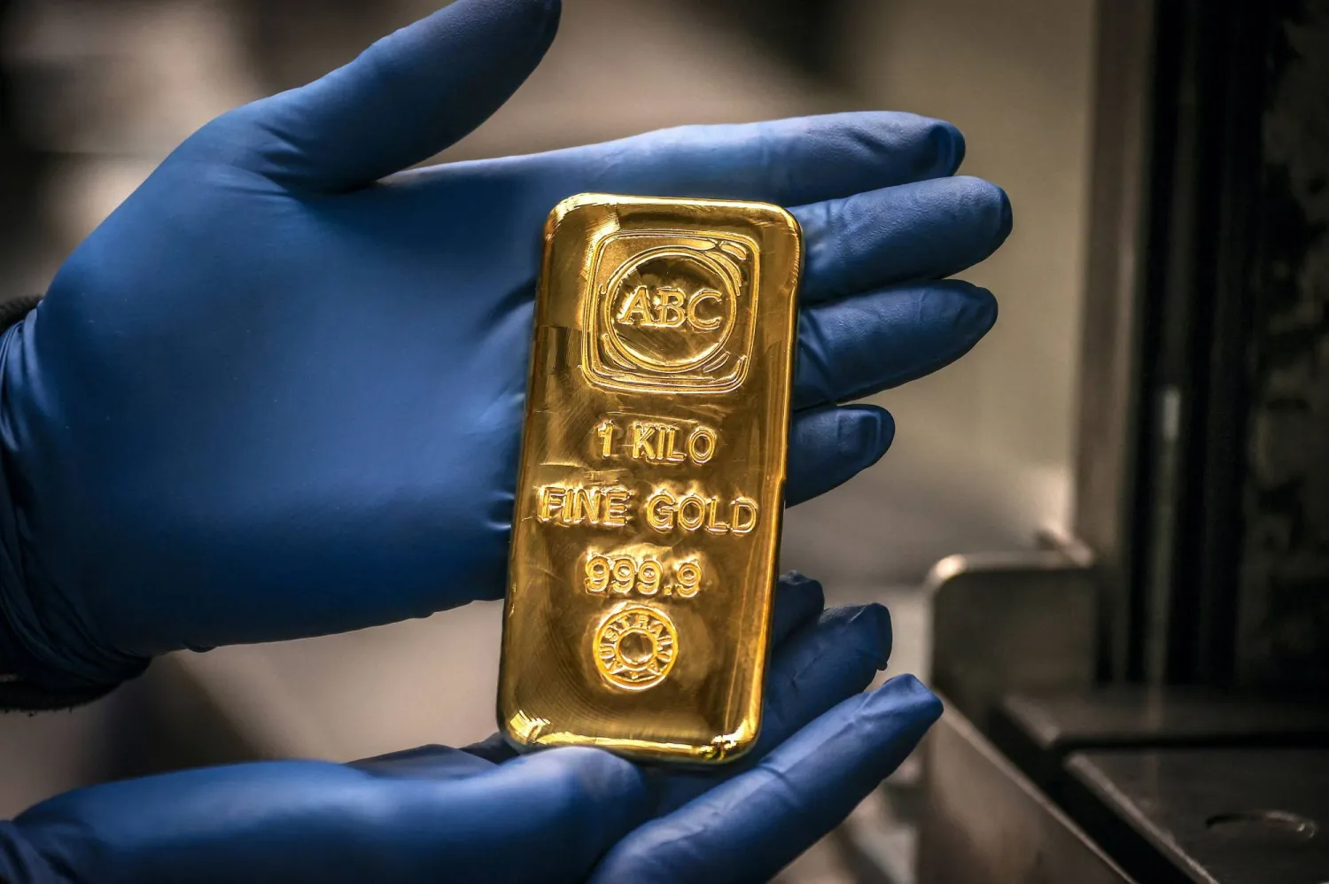 A worker displays a one-kilogram gold bar at a refinery in Sydney (AFP)
