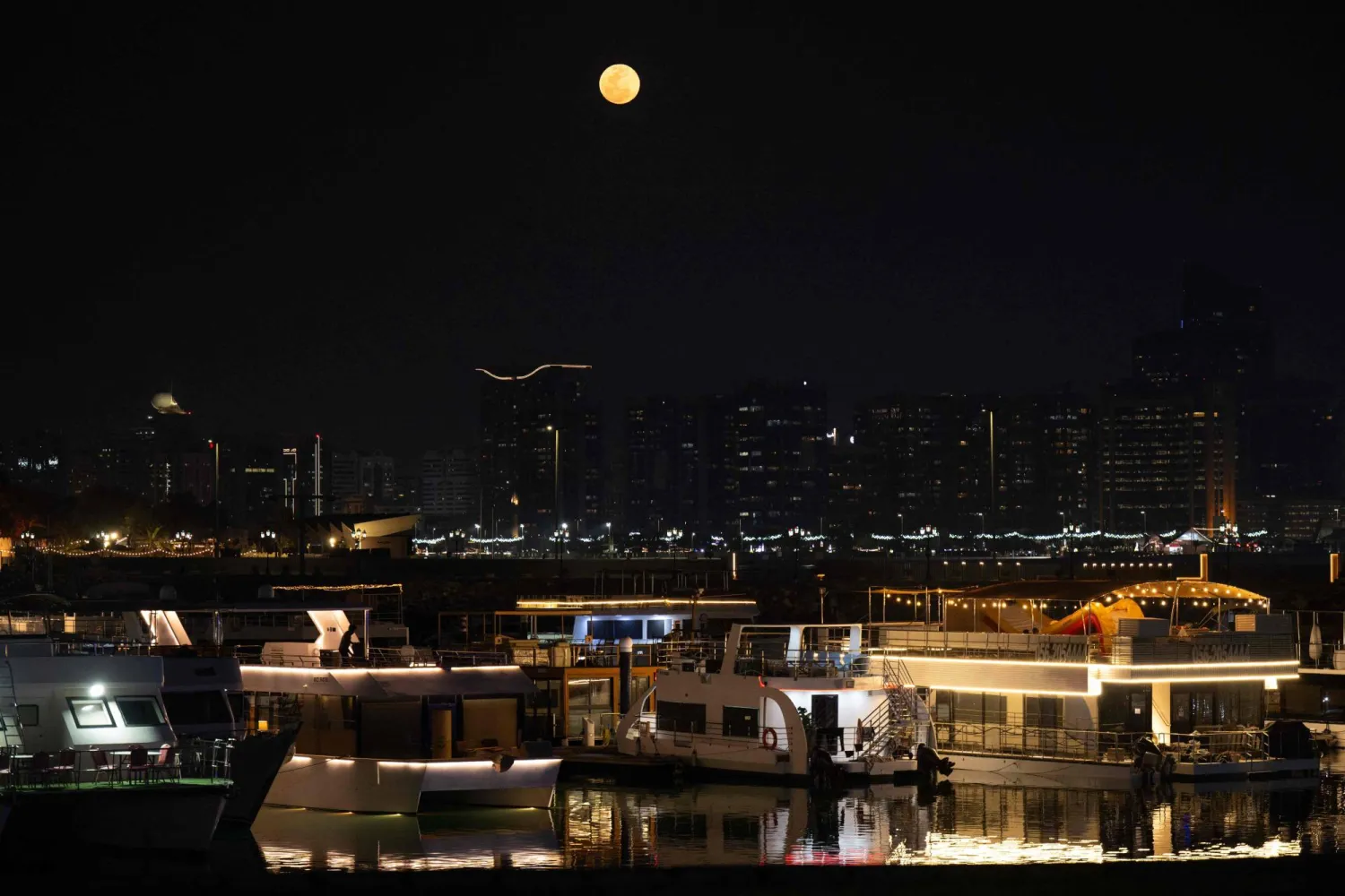 A full moon also known as the "Blood Moon" is seen above the Abu Dhabi skyline on March 3, 2026. (Photo by Ryan Lim / AFP)