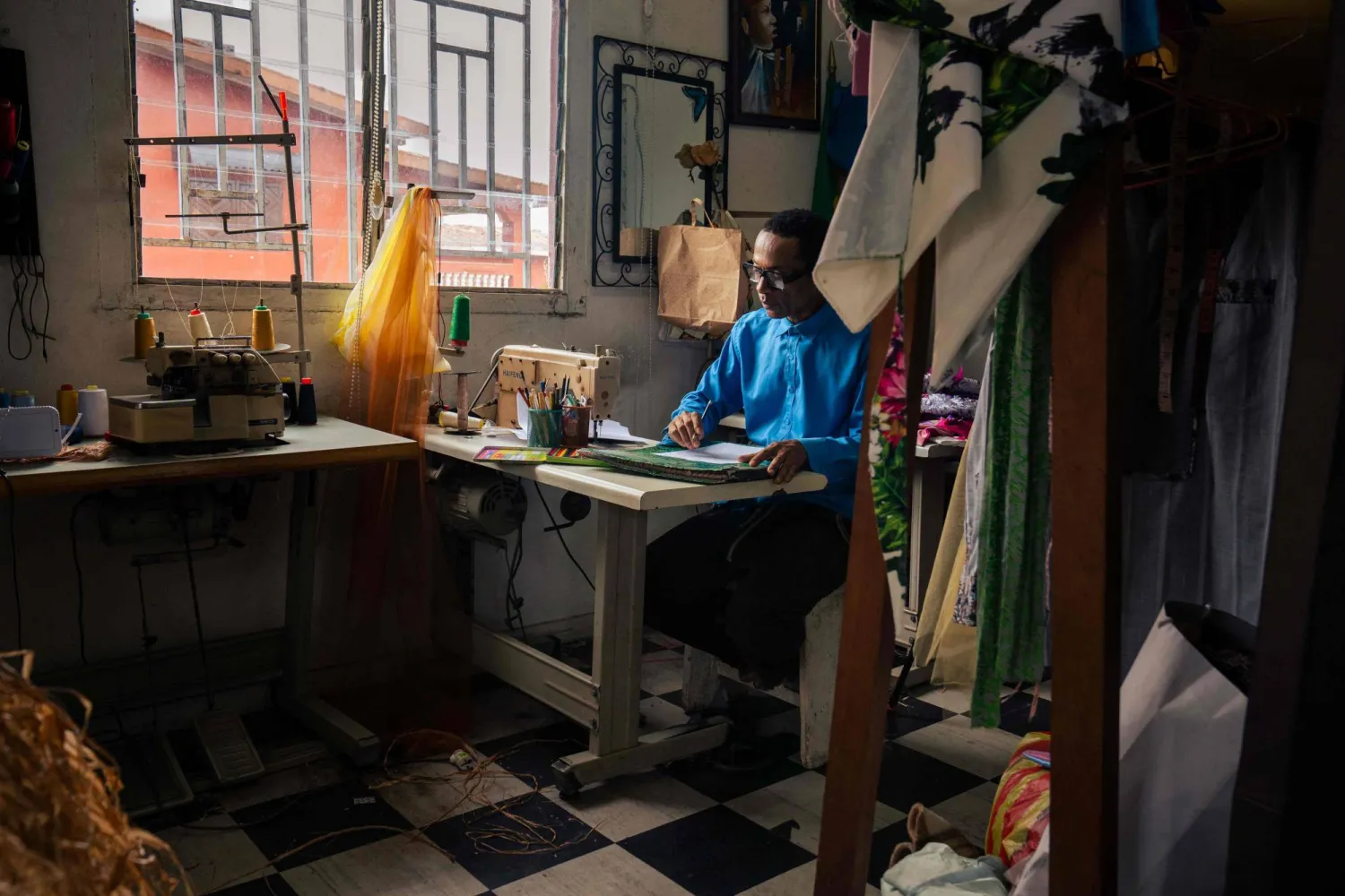 Gabonese fashion designer Chouchou Lazare sketches a design for a dress inside his tailoring workshop in Libreville on February 9, 2026. (AFP) 