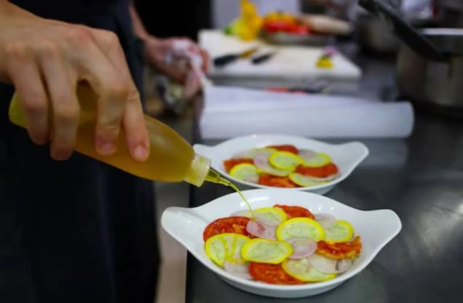 طباخ يحضر الأطباق في مطعم باريسي (رويترز)