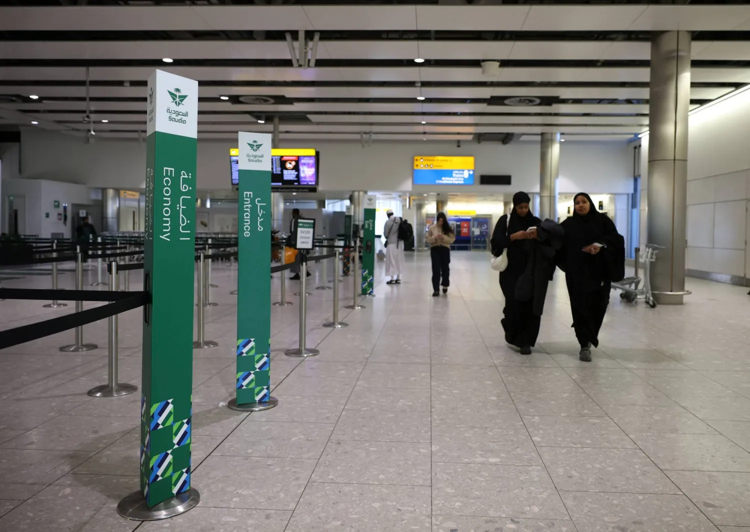 مسافرون يمرون بمنطقة تسجيل الركاب التابعة لـ«الخطوط السعودية» في مطار هيثرو (رويترز)