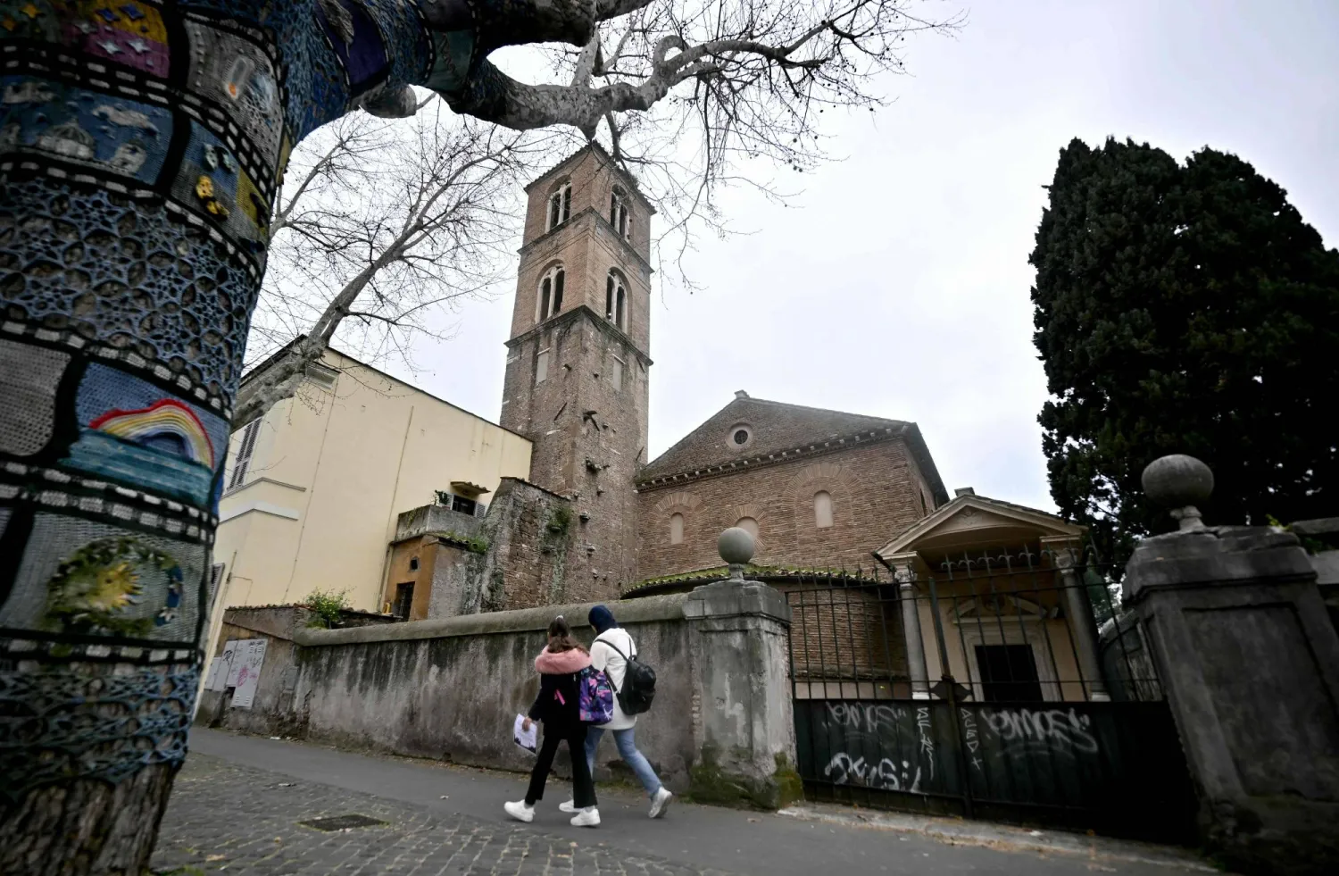 Pedestrians walk past the Basilica of Santa Agnese Outside the Walls as a marble bust is displayed inside after being identified as a work by Michelangelo Buonarroti after centuries without attribution, following a decade of archival research by Italian researcher Valentina Salerno in Rome on March 4, 2026. (AFP)
