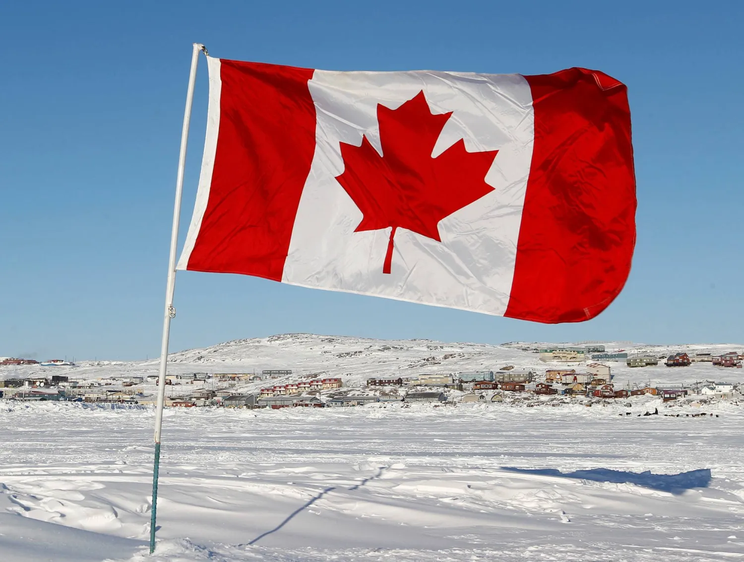 A Canadian flag is pictured on Frobisher Bay in Iqaluit, Nunavut February 23, 2012. REUTERS/Chris Wattie/File
