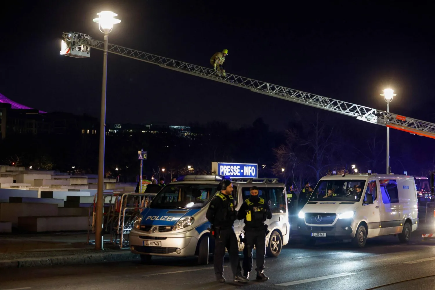(FILES) Members of the emergency services use a crane as they work at the scene where a person was stabbed near the memorial of the murdered jews of Europe in Berlin on February 21, 2025. (Photo by Odd ANDERSEN / AFP)