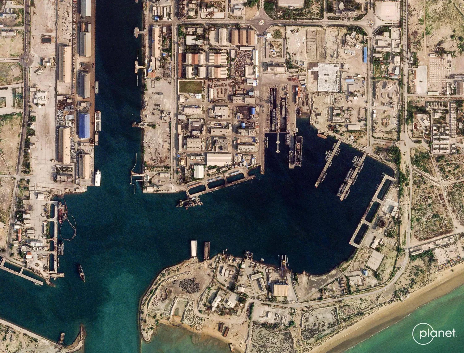 This handout satellite image taken by 2026 Planet Labs PBC shows damage at the military harbor in Iran's southern port of Bandar Abbas along the Strait of Hormuz on March 4, 2026. The United States and Israel launched strikes against Iran on February 28, with the killing of Iran's supreme leader and the Islamic republic retaliated with barrages of missiles at Gulf states and Israel. (Photo by 2026 Planet Labs PBC / AFP) 