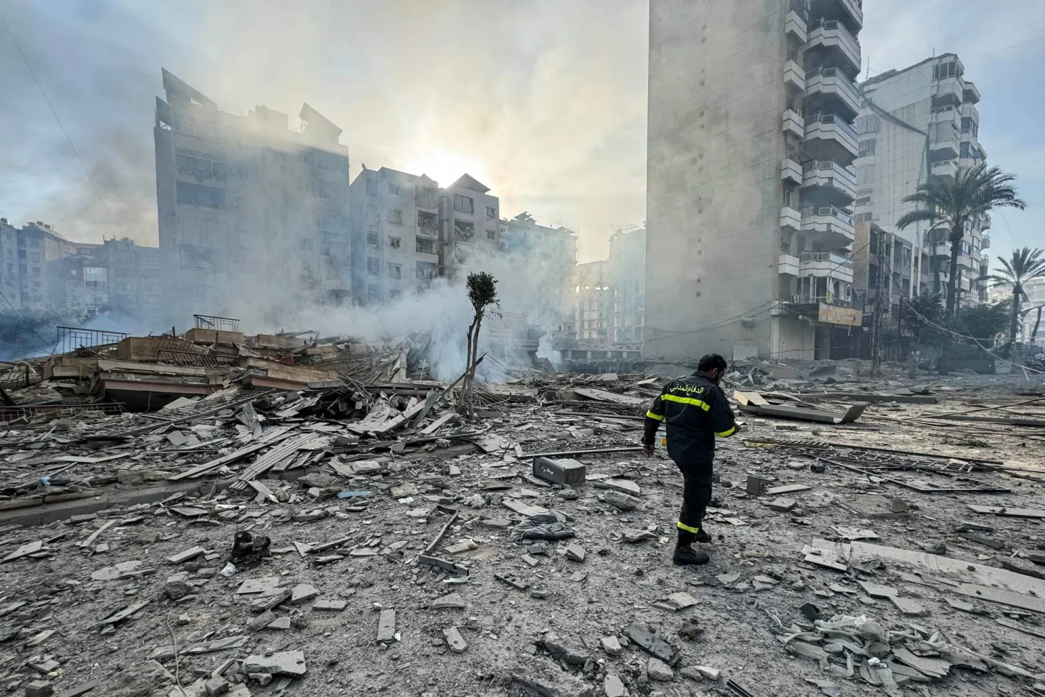 A member of the civil defense makes his way through debris at the site of overnight Israeli airstrikes in the southern suburbs of Beirut on March 6, 2026. (AFP)