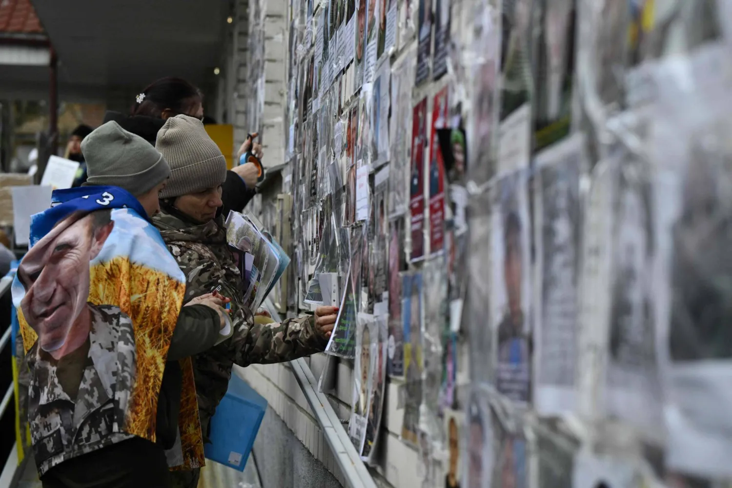 Families place portraits their missing or captured relatives and friends before the arrival of released Ukrainian prisoners of war (POW) after a prisoners exchange in the Chernigiv region on March 5, 2026. (AFP)