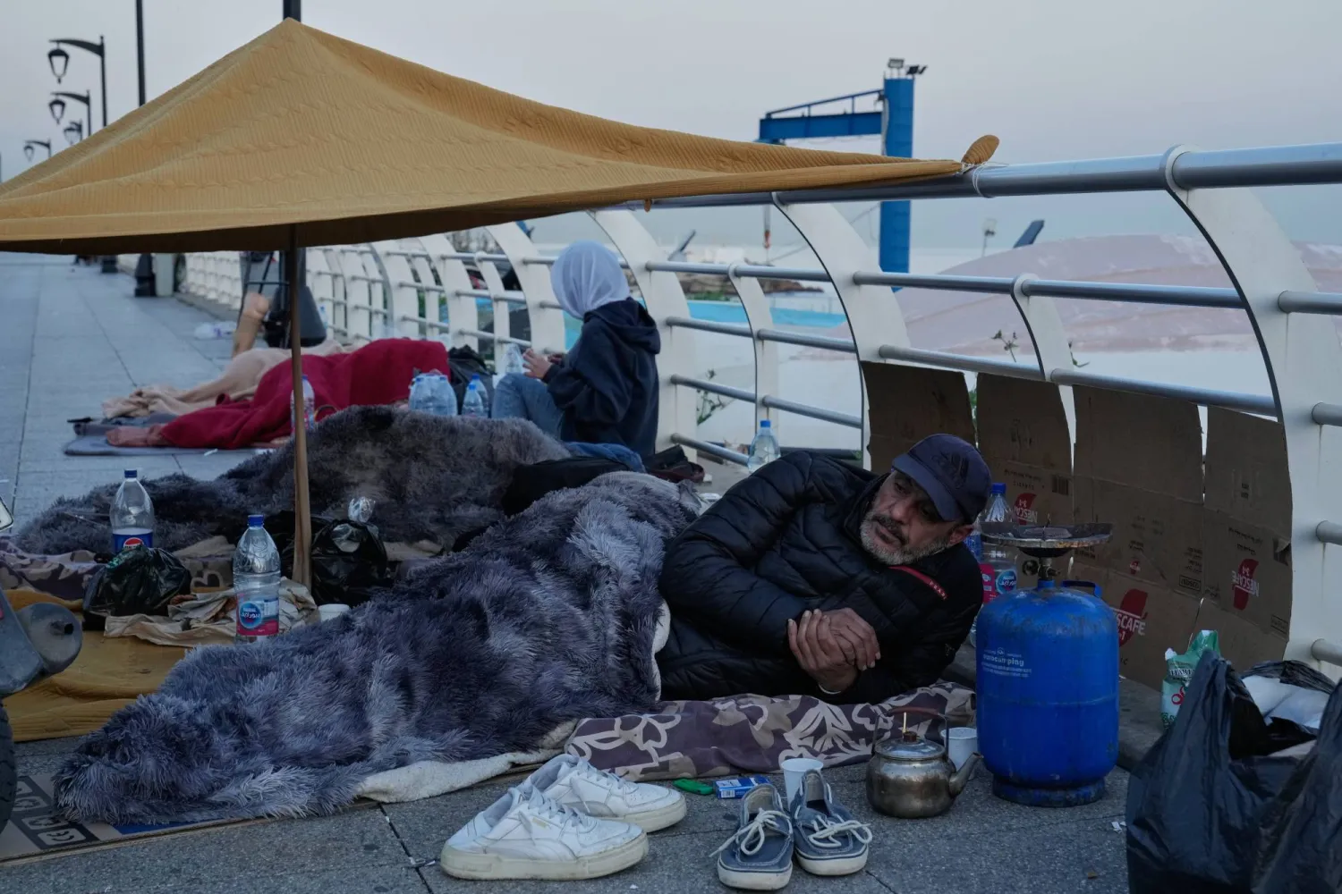 نازحون من الضاحية الجنوبية يقيمون تحت خيمة على الكورنيش البحري لبيروت بعد إنذار إخلاء إسرائيلي (أ.ب)