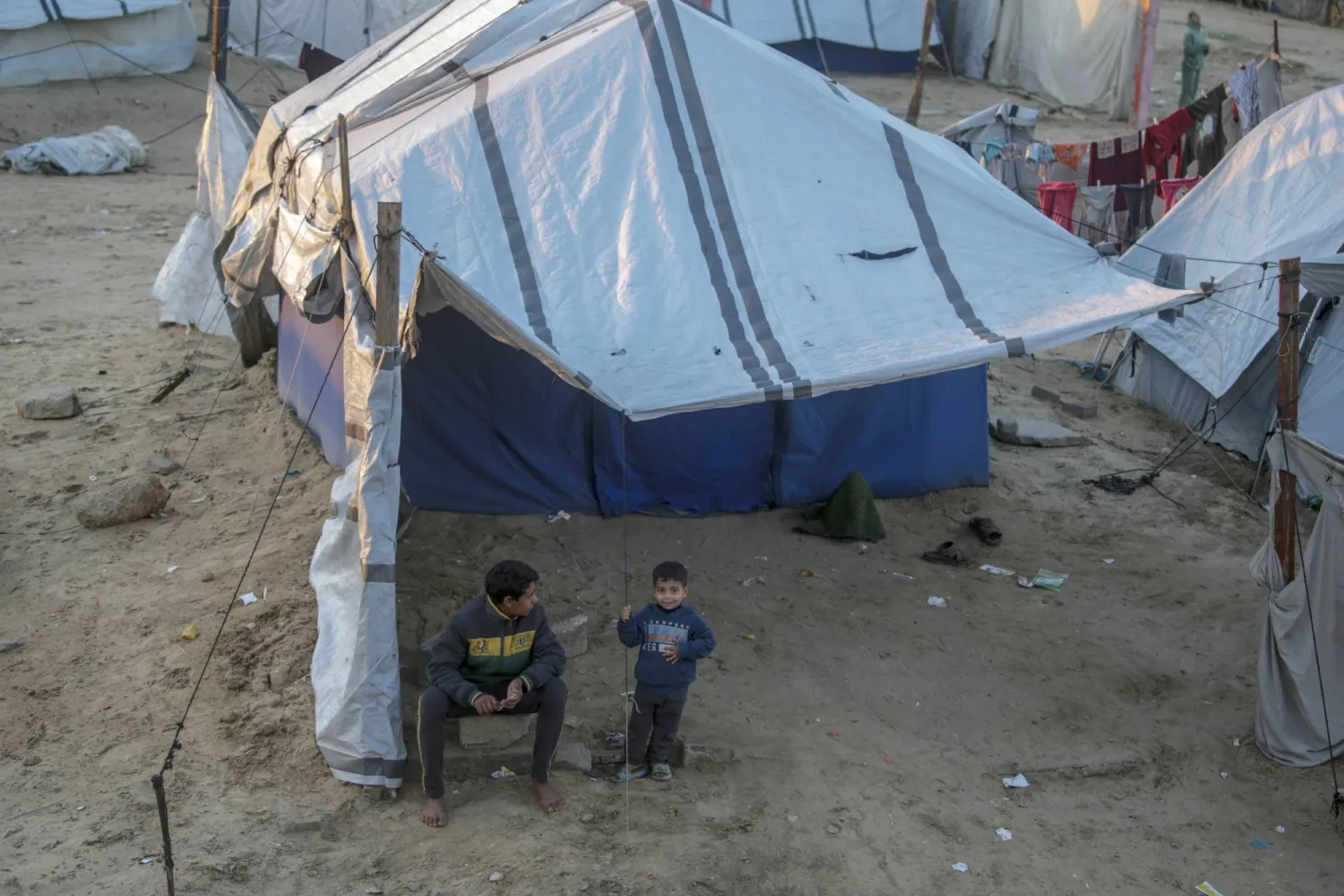 أطفال فلسطينيون نازحون أمام خيام في مدينة غزة (إ.ب.أ)