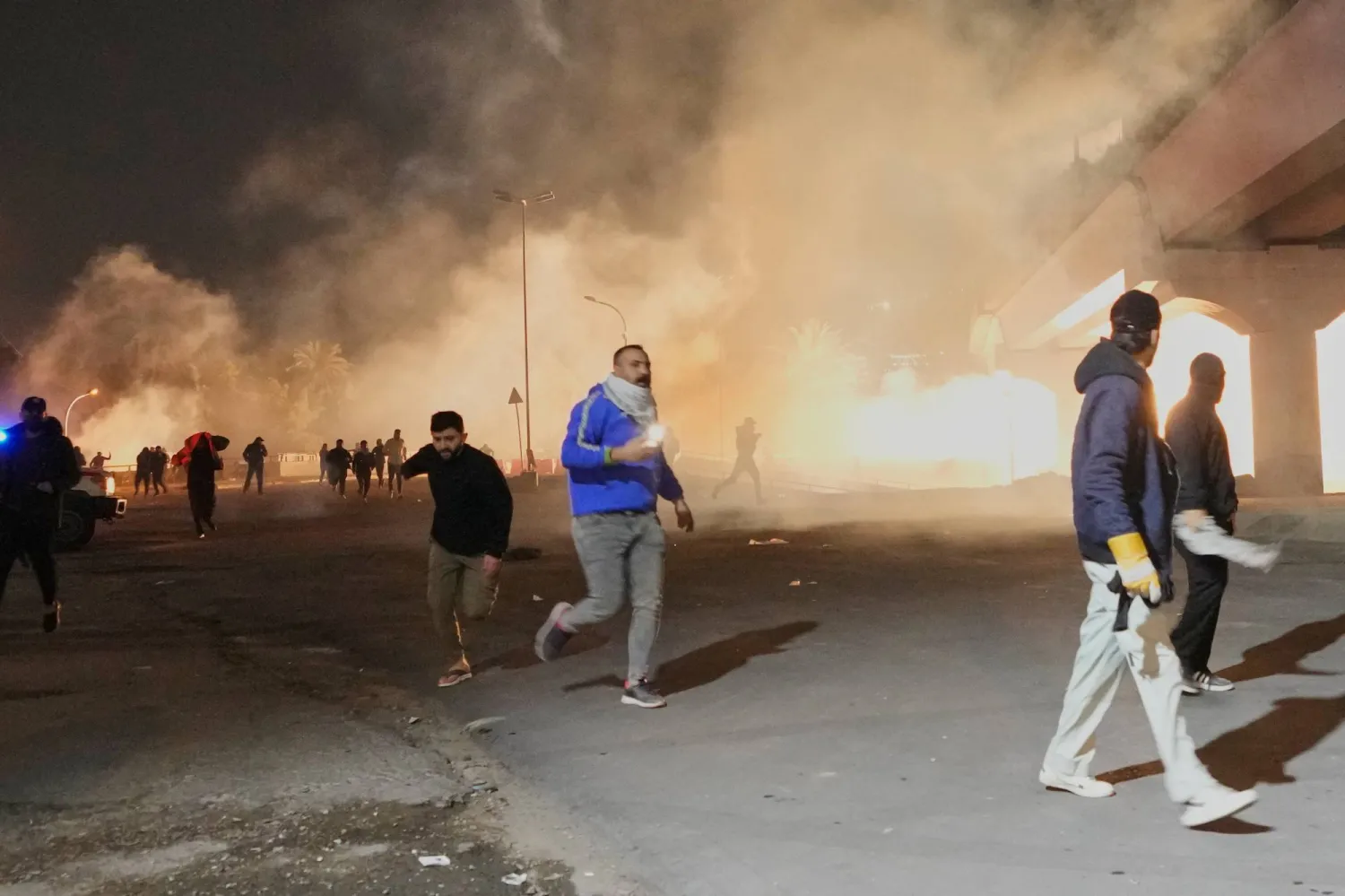 قوات الأمن تطلق الغاز المسيل للدموع لتفريق احتجاج عند جسر يؤدي إلى المنطقة الخضراء حيث تقع السفارة الأميركية في بغداد (أ.ب)