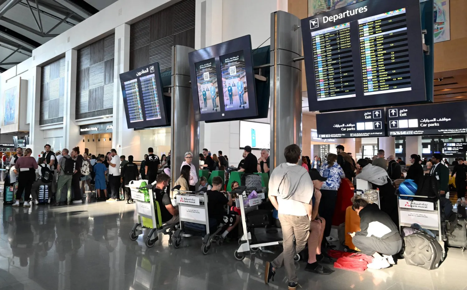 مسافرون في مطار مسقط ينتظرون رحلات الإجلاء يوم 5 مارس (رويترز)