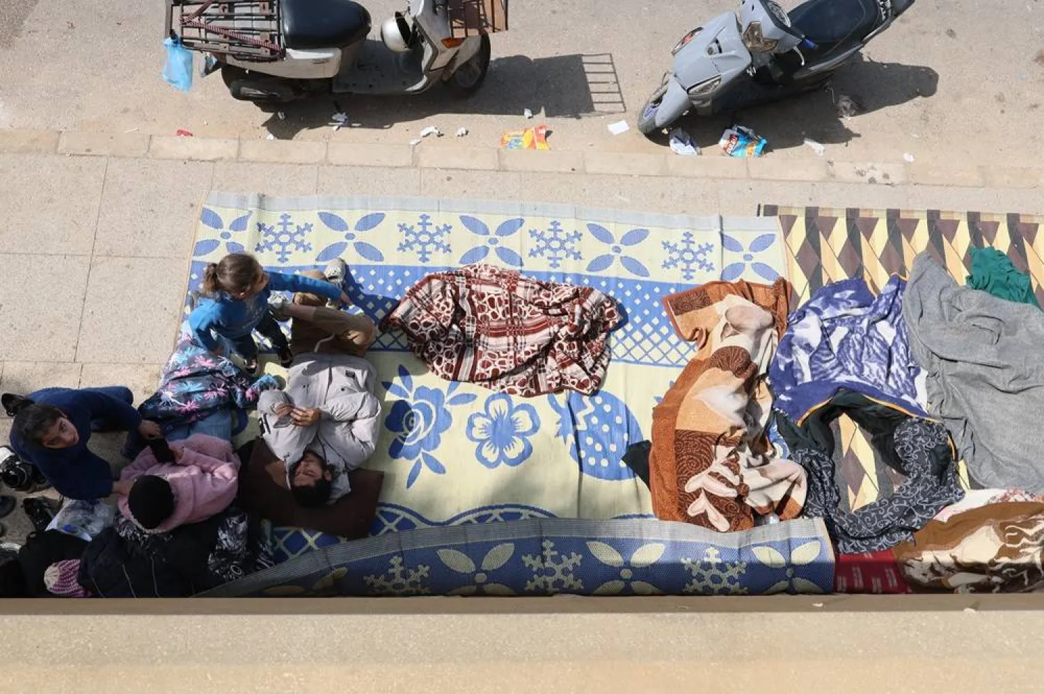 Displaced residents who fled Israeli airstrikes in Beirut's southern suburbs sit on the floor at the corniche waterfront in Beirut, Lebanon, 06 March 2026. (EPA)