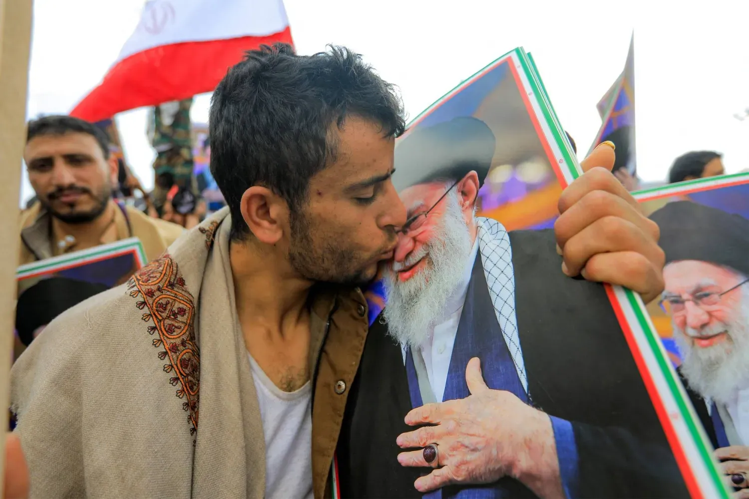 Yemen'in ele geçirilen başkenti Sana'da bir Husi üyesi, Hamaney'in fotoğrafını öpüyor (AFP)