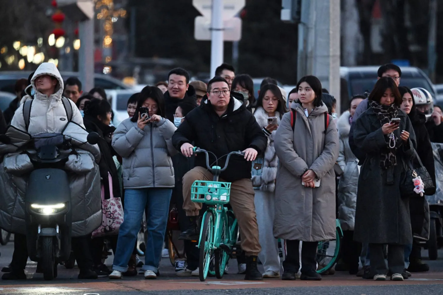 People cross a road in Beijing on March 6, 2026. (AFP)