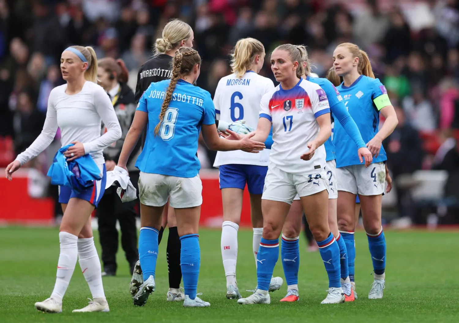 سيدات إنجلترا يصافحن نظيراتهن الآيسلنديات بعد مباراة تصفيات المونديال (رويترز)