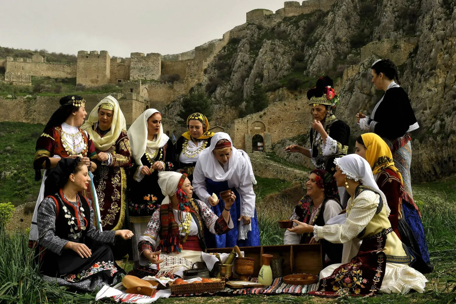 نساء يرتدين أزياء يونانية تقليدية خلال فعالية لليوم الدولي للمرأة في أكروكورينث باليونان (إ.ب.أ)