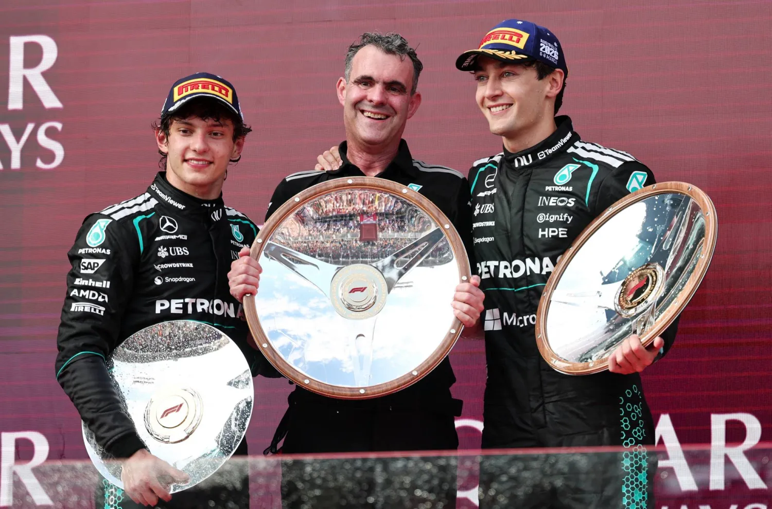 جورج راسل وأنتونيلي وبينهما توماس مدير فريق مرسيدس يحتفلون على منصة التتويج اللأسترالية (رويترز)
