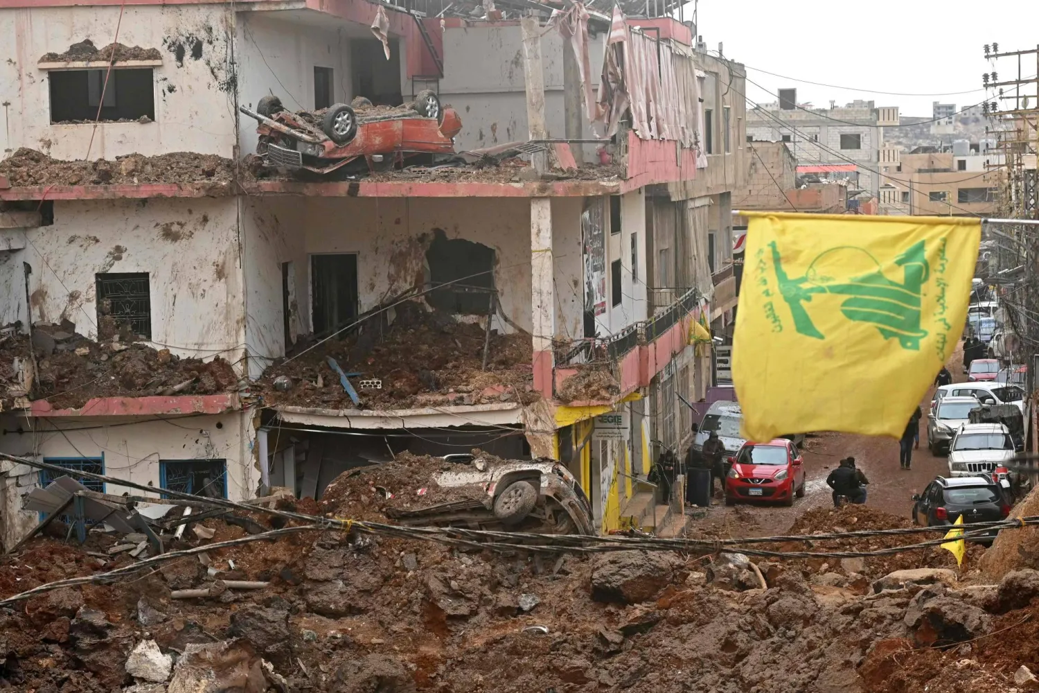 This photograph taken during a media tour organized by the Hezbollah shows a flag of Hezbollah installed on the balcony of a damaged building at Nabi Sheet town after an Israeli military operation in the Bekaa Valley of Lebanon, on March 7, 2026. (Photo by FADEL itani / AFP)