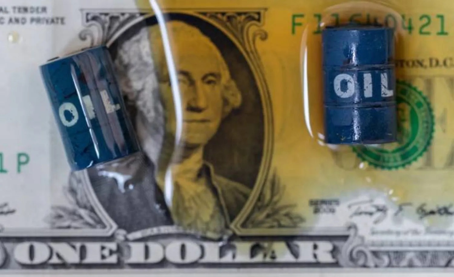 تظهر في هذه الصورة التوضيحية براميل نفط مصغرة وورقة نقدية من الدولار الأميركي (رويترز)