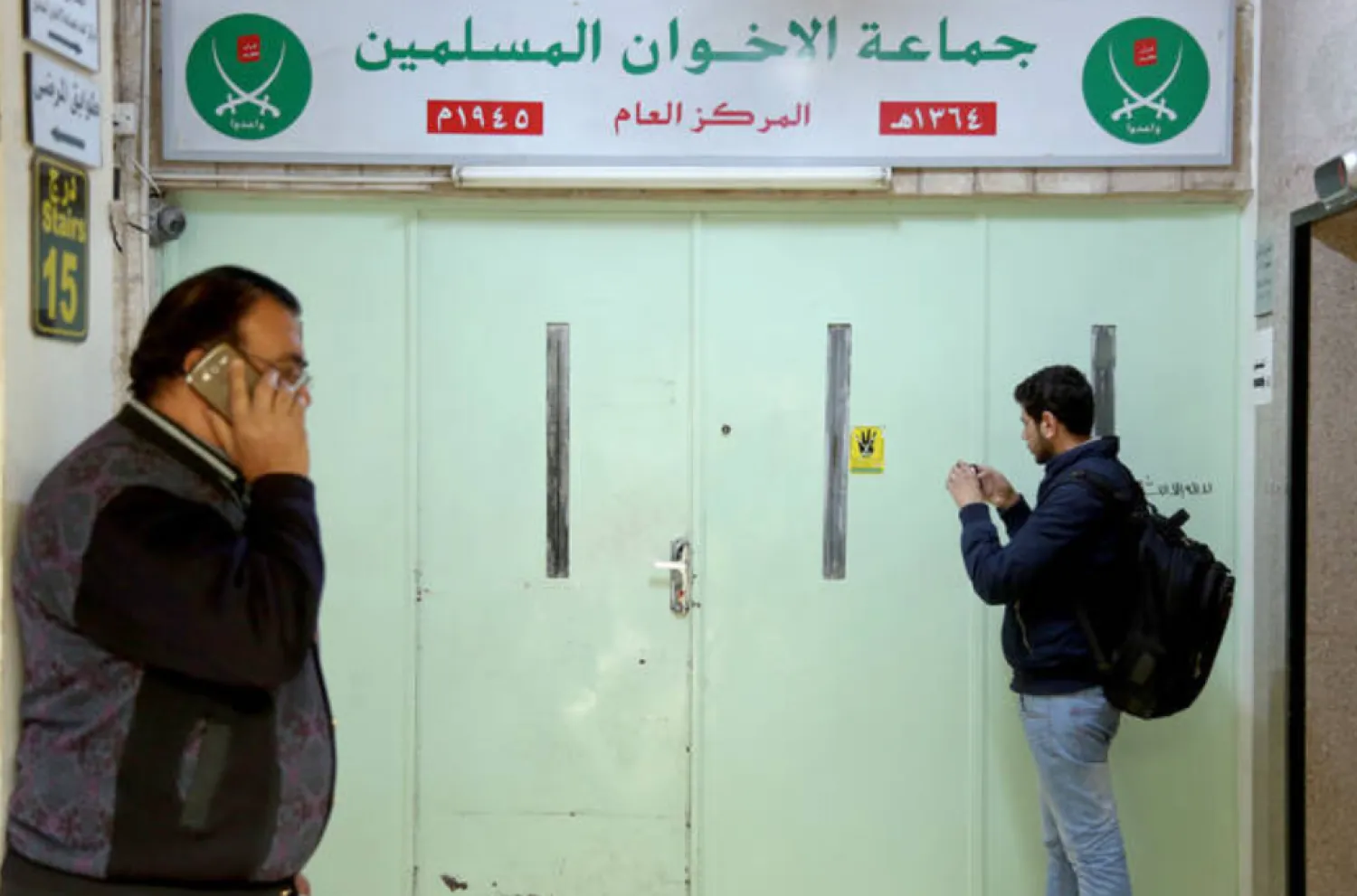 A man photographs the main entrance of the original Muslim Brotherhood office, that is sealed with official wax after it was raided and shut down by police, in Amman, Jordan, Wednesday, April 13, 2016 - AP
