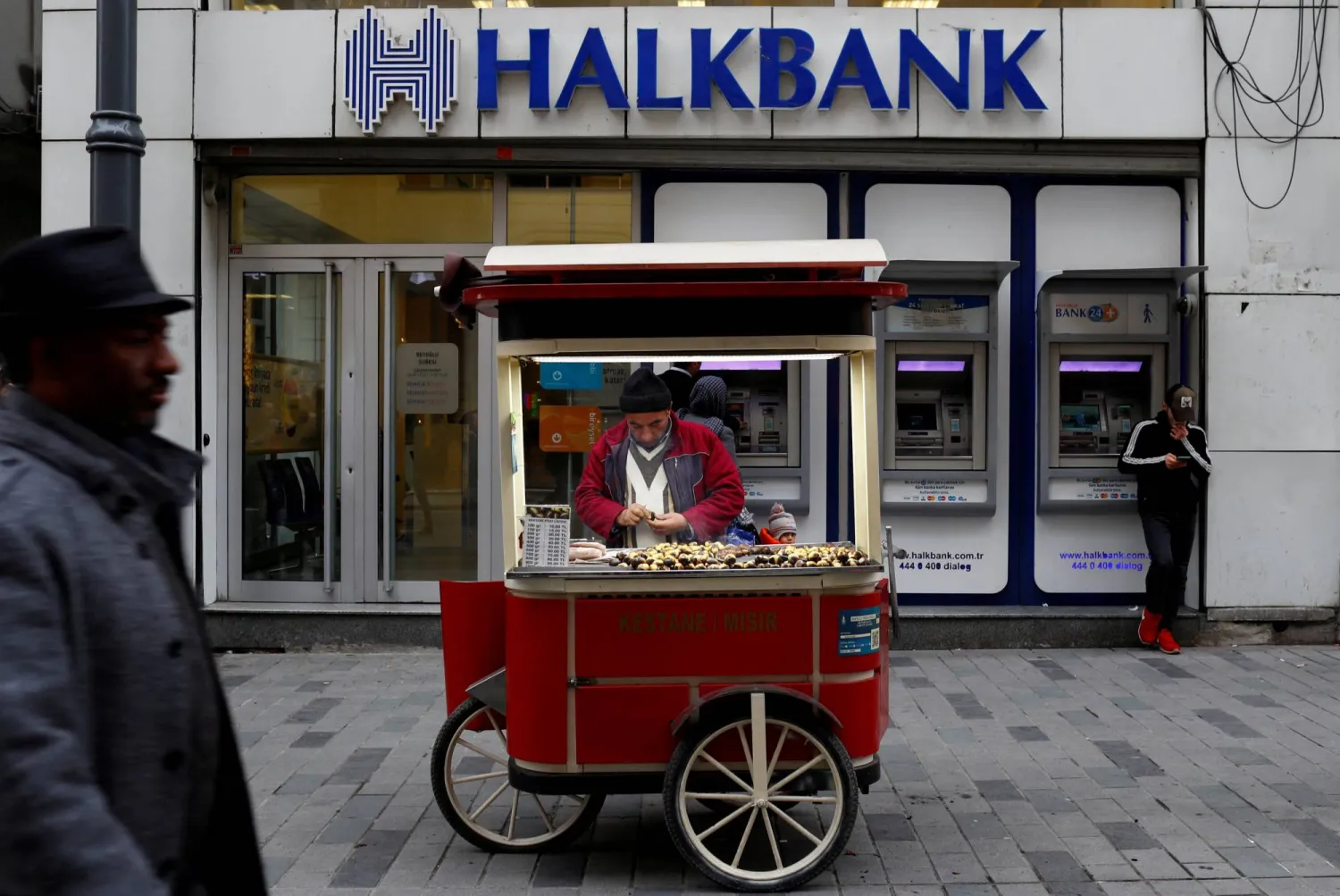 FILE PHOTO: A street vendor sells roasted chestnuts in front of a branch of Halkbank in central Istanbul, January 10, 2018. REUTERS/Murad Sezer/File Photo