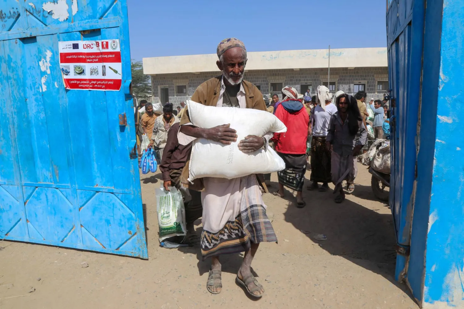 يمني يحصل على معونة غذائية بمحافظة الحديدة حيث يعيش ملايين السكان تحت خط الفقر (أ.ف.ب)