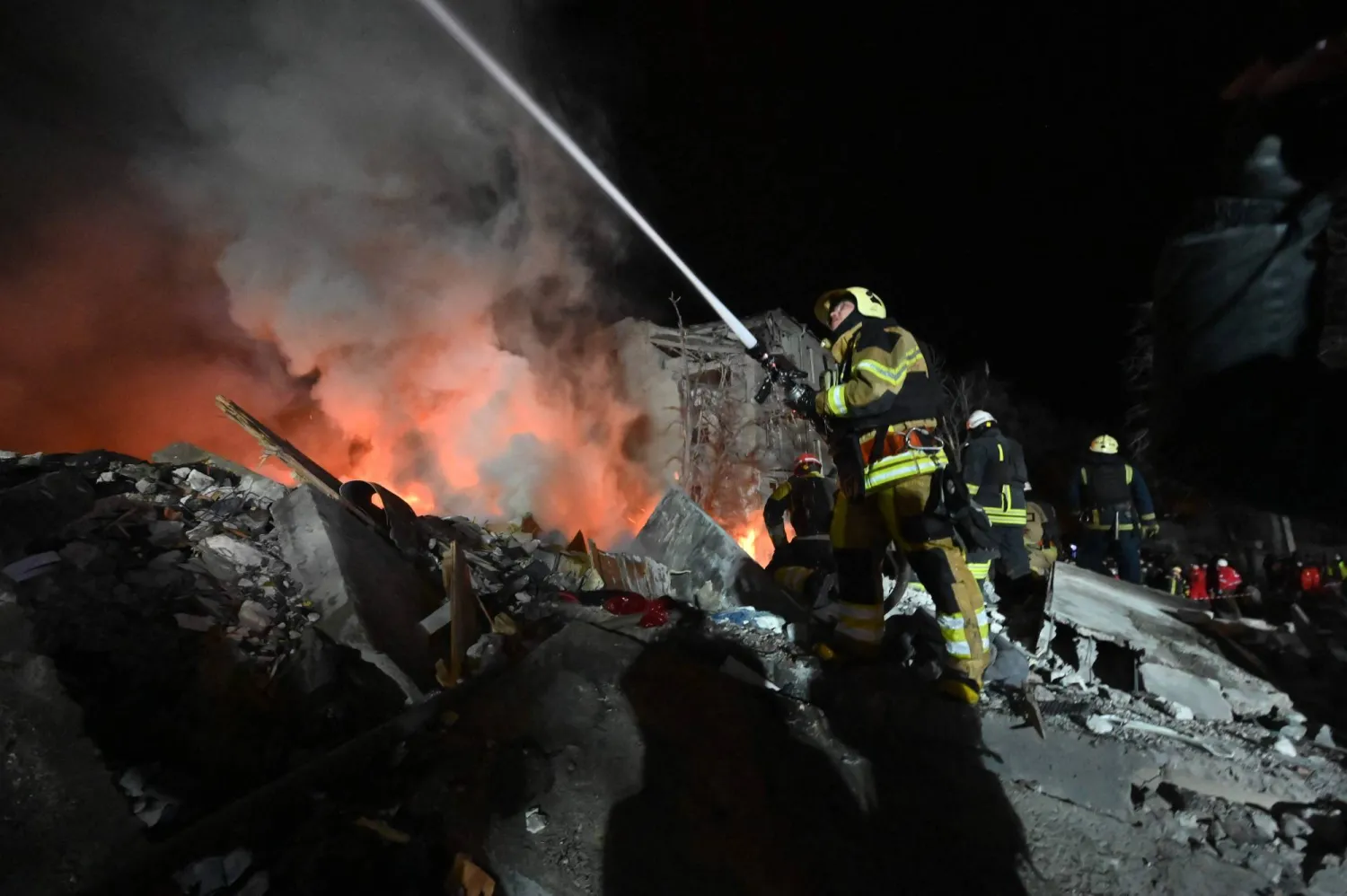 Firefighters extinguish a blaze and clear rubble of a five-story residential building which was hit by a ballistic missile in Kharkiv on March 7, 2026. (AFP)